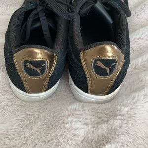 Black Puma sneakers with gold details
